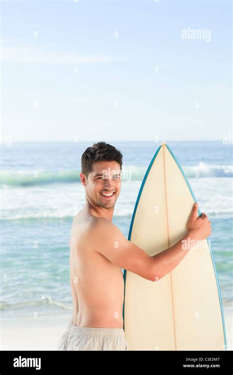 Handsome Man With His Surfboard At The Beach Stock Photo Alamy