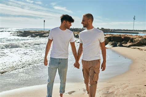 Joven Pareja Gay Sonriendo Feliz Caminando En La Playa Imagen De Archivo Imagen De Paisaje