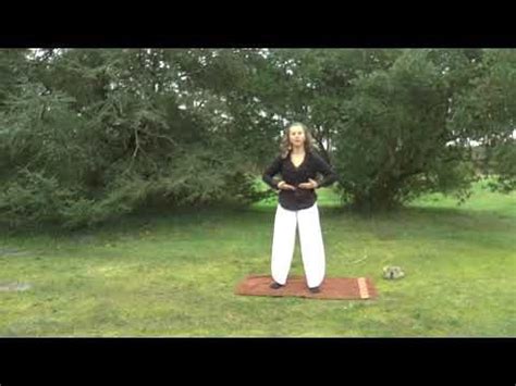 A Woman Standing On Top Of A Yoga Mat In The Middle Of A Field With