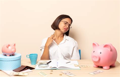 Joven latina sintiéndose estresada ansiosa cansada y frustrada tirando del cuello de la