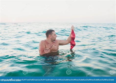 Joven Con El Pelo Largo Rubio Y Topless Sentado En El Agua Y Sosteniendo En Su Mano Un Bikini