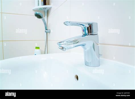 Chromed Metal Faucet For Hot And Cold Water In A Modern Bathroom Stock Photo Alamy