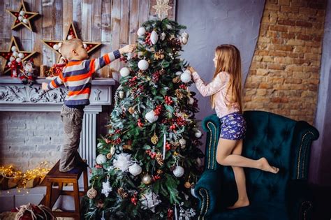 O menino bonito e a menina que decora uma árvore de natal Foto Grátis