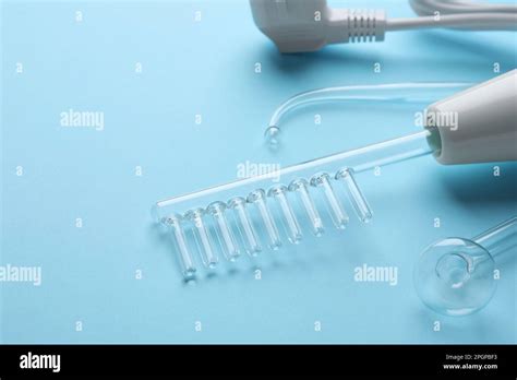 Modern darsonval with nozzles on light blue background, closeup. Space ...