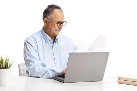 Mature Man Sitting At A Desk And Working On A Laptop Computer Stock Photo Image Of Person