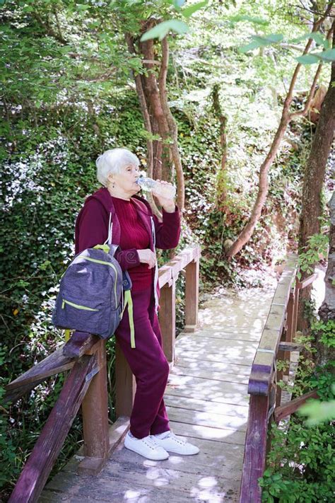 Mature Female Spending Vacations Outdoors Walking In Forest With Rucksack Stock Photo Image