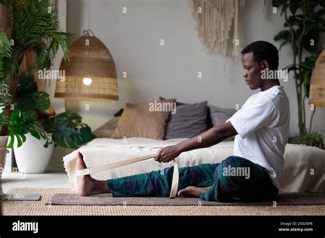 Young African Man Sitting In Janushirshasana Seated Forward Bend
