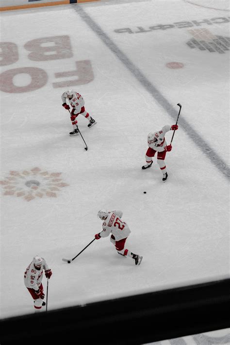 people playing ice hockey  ice field photo  grey image  unsplash