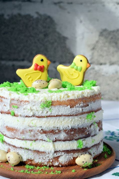Naked Layer Cake Topped With Gingerbread Cookies Shaped Like Yellow Chicks Decorated With Green