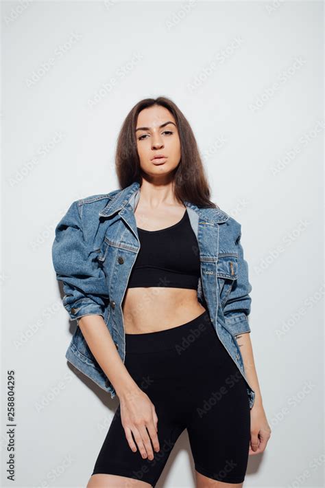 Slender Brunette Girl In A Sports Top And Denim Jacket Emotional Portrait Of A Student Sexy