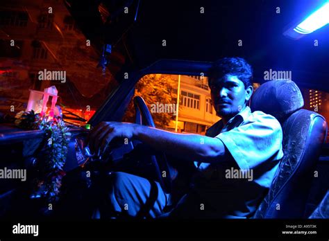 Indian Taxi Driver Waiting For Fare Beneath Neon Lights Mumbai India