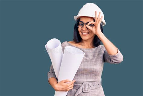 Joven Y Hermosa Latina Que Lleva El Sombrero Duro Del Arquitecto Y Gafas Sosteniendo Planos
