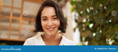 Close Up Portrait Of Beautiful Brunette Asian Girl Smiling And Looking Flirty At Camera