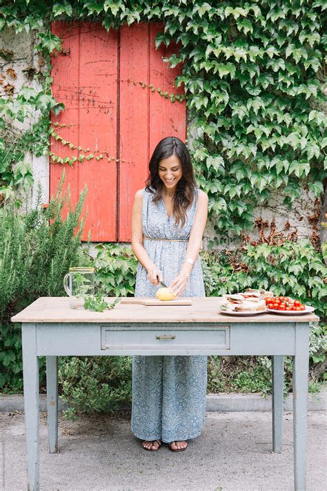 Beautiful Smiling Brunette Woman Cutting Lemon By Stocksy Contributor Studio Serra Stocksy
