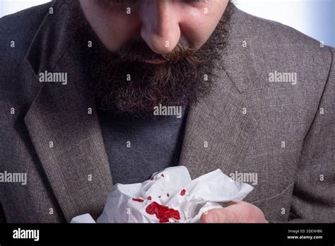 bloody cough, bearded businessman coughing up blood into a napkin ...