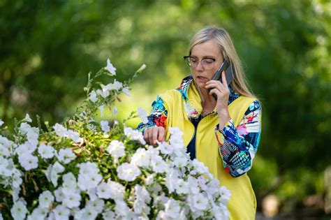Femme Mature Blonde Habill E En Pleine Couleur Parlant Sur Smartphone Dans Jardin Concept De