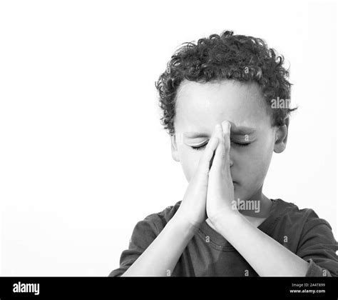 Boy Praying To God With Hands Held Together With Closed Eyes Stock