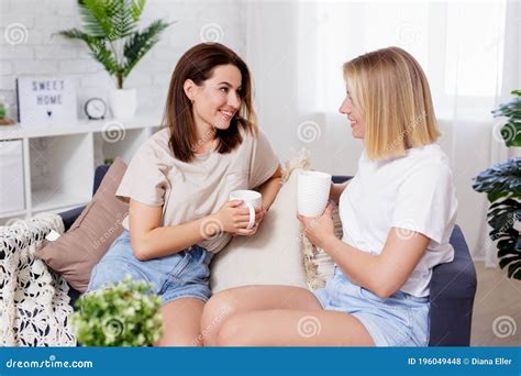 Female Friendship Two Happy Young Women Talking In Cozy Living Room