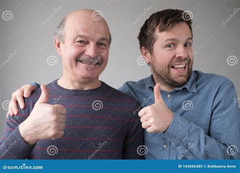 Two Caucasian Mature Men Father And Son Look At Camera Show Thumbs Up Stock Image Image Of