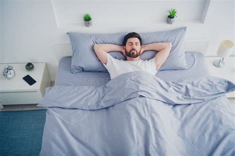 Top View Photo Of Handsome Good Mood Mature Guy Dressed Sleepwear Lying Bed Arms Behind Head