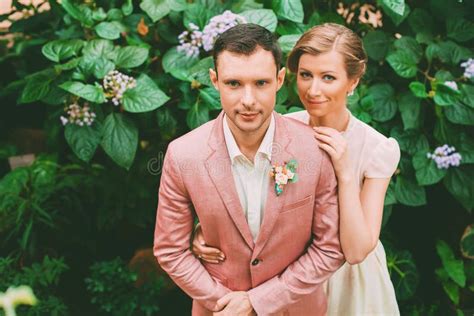 Groom And Bride Standing Near Bush With Flowers Stock Image Image Of