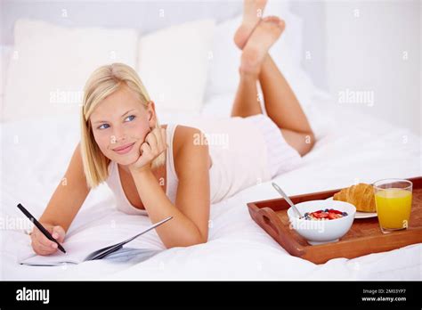 Planifier ma journée Femme blonde couchée sur son lit et écrivant dans son journal intime avec