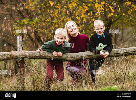 Preteen Twin Blonde Brothers Playing Outdoors With Happy Single Mom At Beautiful Warm Autumn