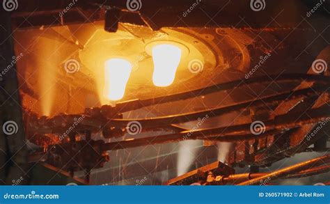 Molten Glass Pouring Out Of A Glass Melting Furnace In A Bottle Production Facility Glass