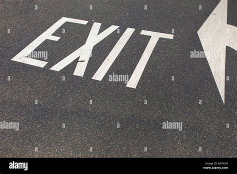 Exit Sign Painted On Asphalt With Directional Arrow Indicating The Way