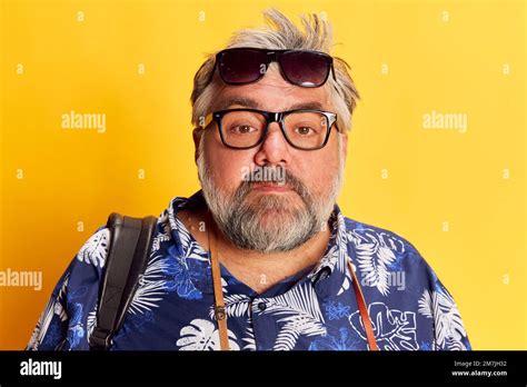 Portrait Of Fat Mature Man In Stylish Shirt Posing With Glasses And Sunglasses Over Bright