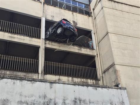 Carro fica pendurado em garagem de prédio na avenida Rio Branco