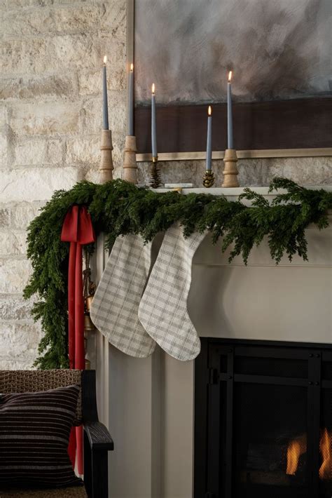 Christmas Stockings Hanging From A Mantle With Candles