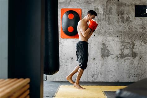 Premium Photo Brutal Dark Haired Guy With A Naked Torso And The Red Boxing Gloves Stands