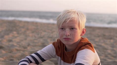 A Handsome Blond Boy Sits On The Beach By The Sea Stock Video Video Of Blonde Fingers