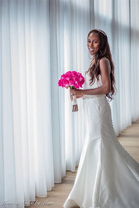 A Woman In A Wedding Dress Holding A Bouquet Of Flowers