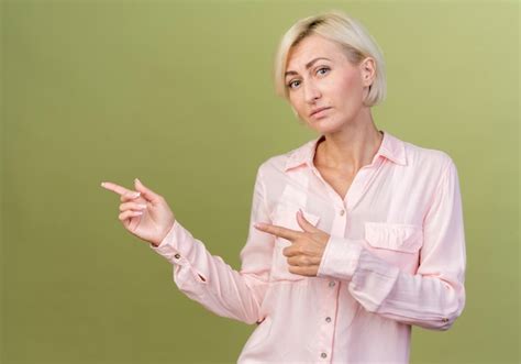 Regardant la caméra jeune femme slave blonde pointe sur le côté Photo Gratuite