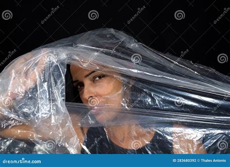 A Woman With A Plastic Bag Over Her Head Looking Through A Hole