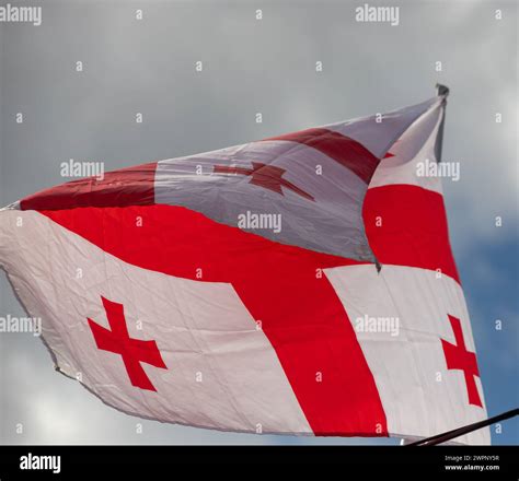 Georgia National Flag Cloth Fabric Waving On The Sky With Beautiful Sun Light Image Stock