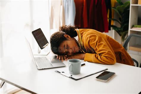 Calm Curly Brunette Dark Skinned Woman On Desk In Office Of Fashion Designer And Holds Tablet