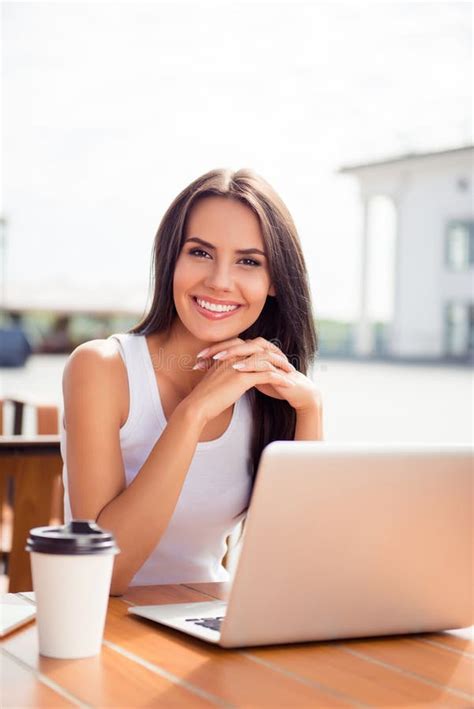 Portrait Of Beautiful Smiling Woman Sitting In A Cafe With Laptop Stock