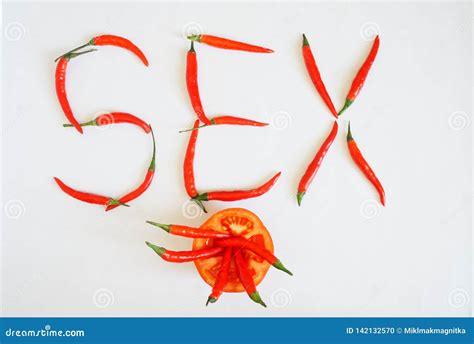 Half A Tomato And Red Hot Chili Peppers Lie On A White Surface Vegetables Make Up The Word Sex