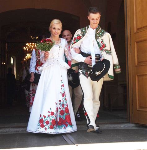 A Man And Woman Dressed In Traditional Clothing Walking Out Of A