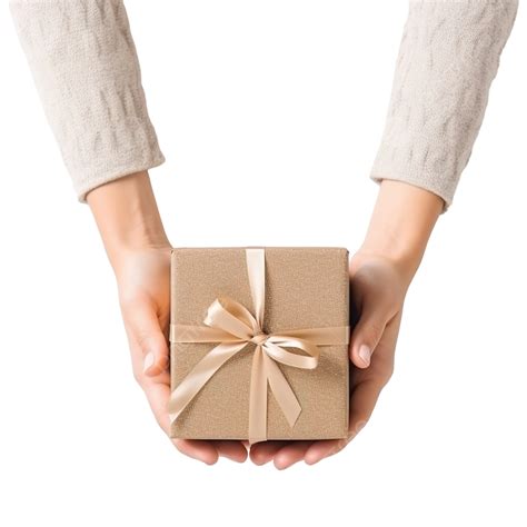 Female Hands Hold T Box Next To Christmas Decoration On A Table