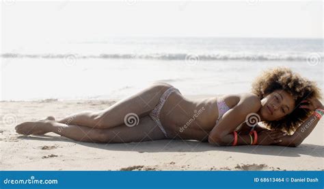 Mujer En El Bikini Que Miente En La Playa Tropical Foto De Archivo