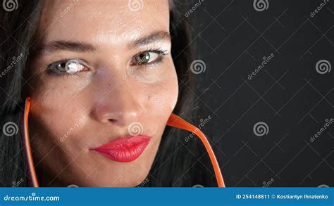 Portrait Of A Brunette Woman With Red Lips Who Eroticly And Playfully Tries On Stylish Glasses