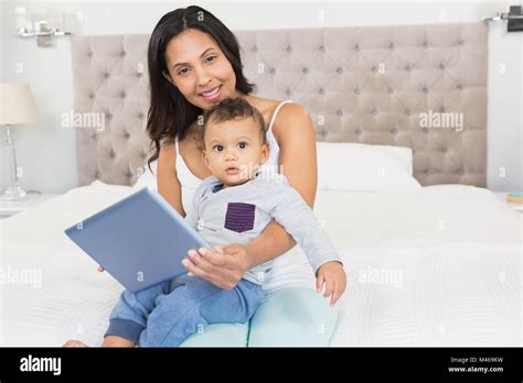 Happy Brunette Holding Her Baby And Using Tablet Stock Photo Alamy