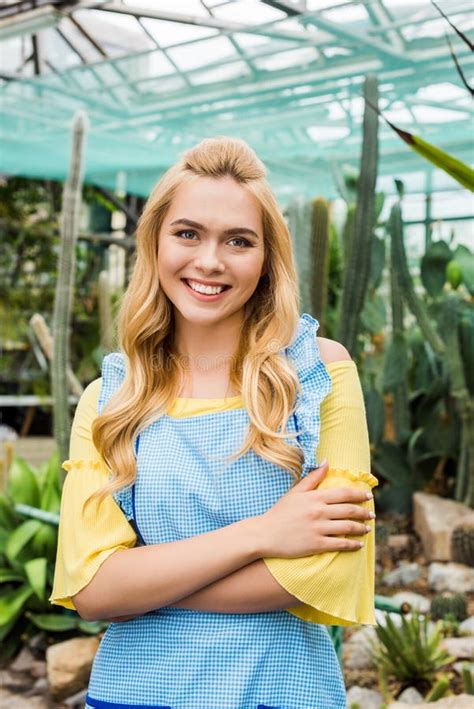 Beautiful Blonde Woman In Apron Standing With Crossed Arms And Smiling At Camera Stock Image