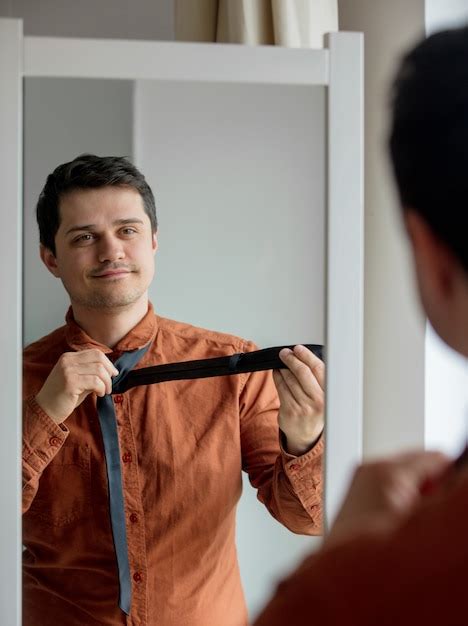 Premium Photo Candid View On Young Man Dressing Up Near Mirror