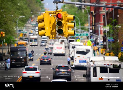 The Hanging Yellow Traffic Lights Over A Busy Street In New York Usa