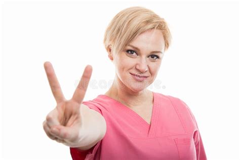 Attractive Female Nurse Wearing Pink Scrubs Showing Peace Gesture Stock